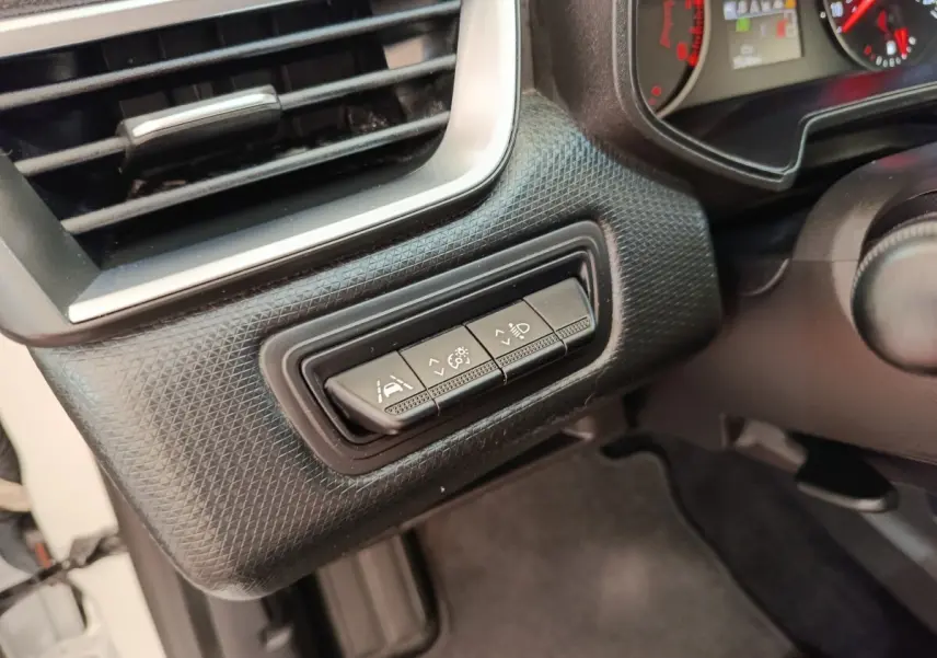 Détail intérieur côté gauche du tableau de bord de la Renault Clio Business blanc, avec commandes d’assistance à la conduite.