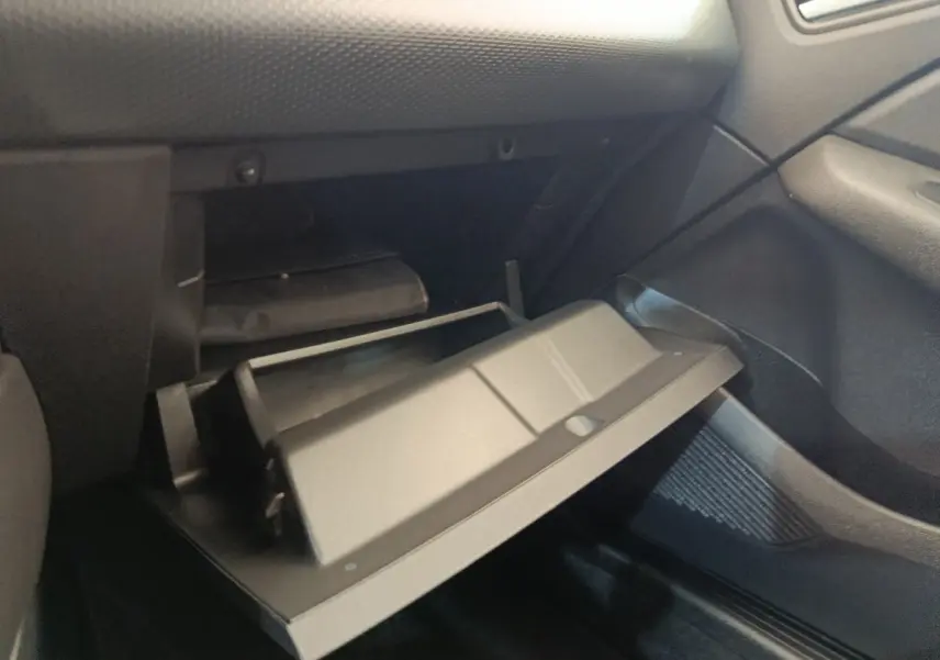Gant de boîte à gants ouvert côté passager dans l’habitacle noir d’une Renault Clio Business blanc 2021.