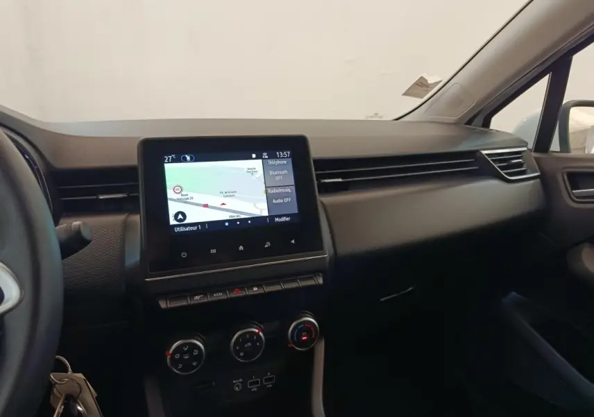 Vue intérieure du tableau de bord de la Renault Clio Business TCe 100 GPL 2021 avec écran tactile central et commandes de climatisation.
