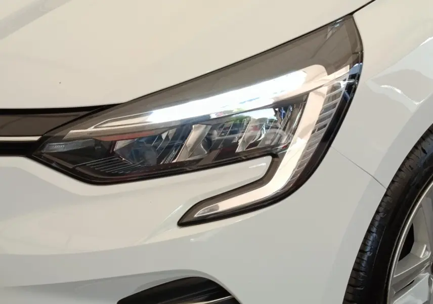 Gros plan sur le phare avant droit blanc de la Renault Clio Business TCe 100 GPL 2021 avec jante visible.