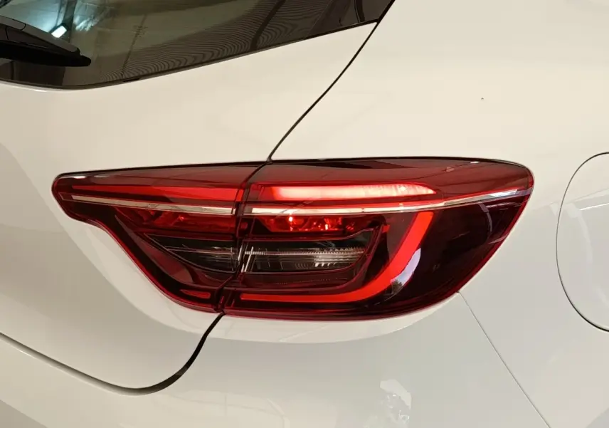 Gros plan sur le feu arrière droit rouge d’une Renault Clio Business blanc nacré, vue de côté arrière.