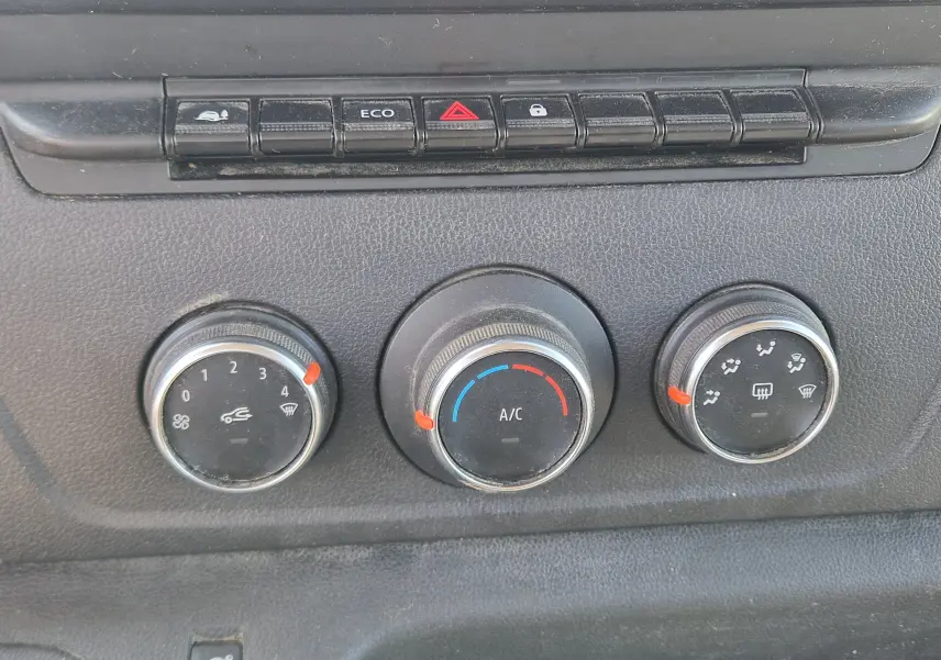 Gros plan sur les commandes de lève-vitres et réglage des rétroviseurs côté conducteur du Renault Master blanc.