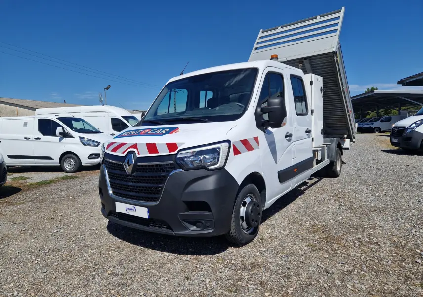 Renault Master blanc en 3/4 avant droit avec benne relevée et marquages rouges et blancs sur la carrosserie.