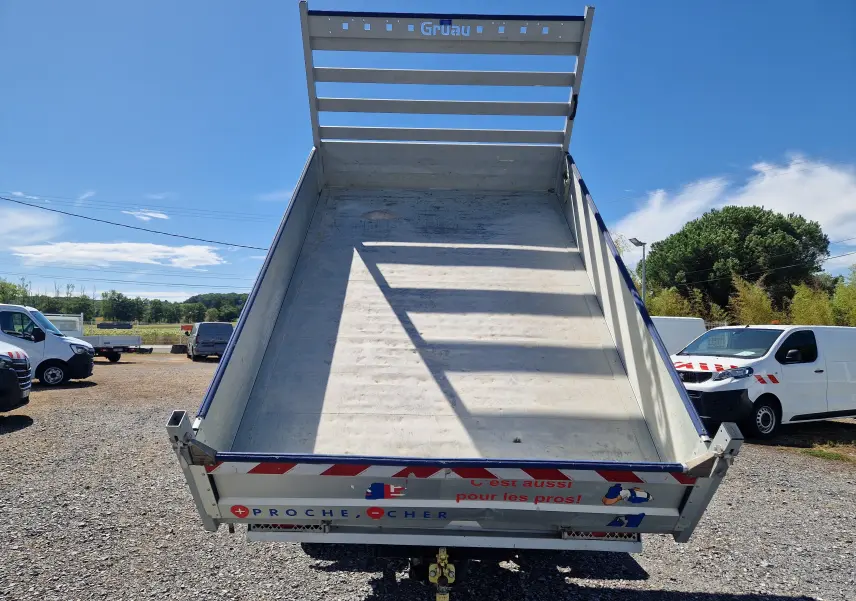 Vue arrière d’une benne relevée blanche sur un Renault Master Châssis Double Cab 2022 avec coffre et marquage réfléchissant.