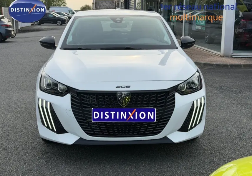 Vue avant d'une Peugeot 208 blanche Okénite avec calandre noire et feux diurnes LED en griffes verticales.