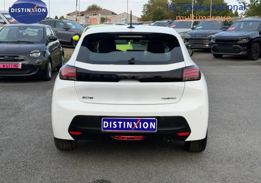 Vue arrière d'une Peugeot 208 blanche Okénite avec logo noir brillant et feux arrière LED horizontaux.