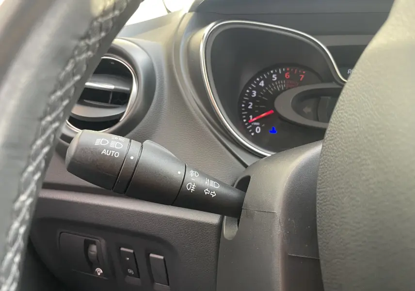 Gros plan sur la manette de commandes d'éclairage du tableau de bord du Renault Captur noir ivoire, intérieur gris-beige.