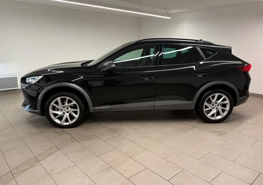 Profil côté gauche d'un CUPRA Formentor 1.5 TSI noir minuit 2024, avec jantes argentées et lignes dynamiques marquées.