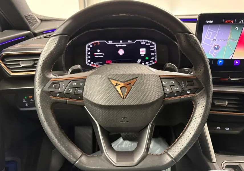 Vue rapprochée du volant noir perforé avec logo CUPRA cuivré et tableau de bord numérique du Formentor 2024.