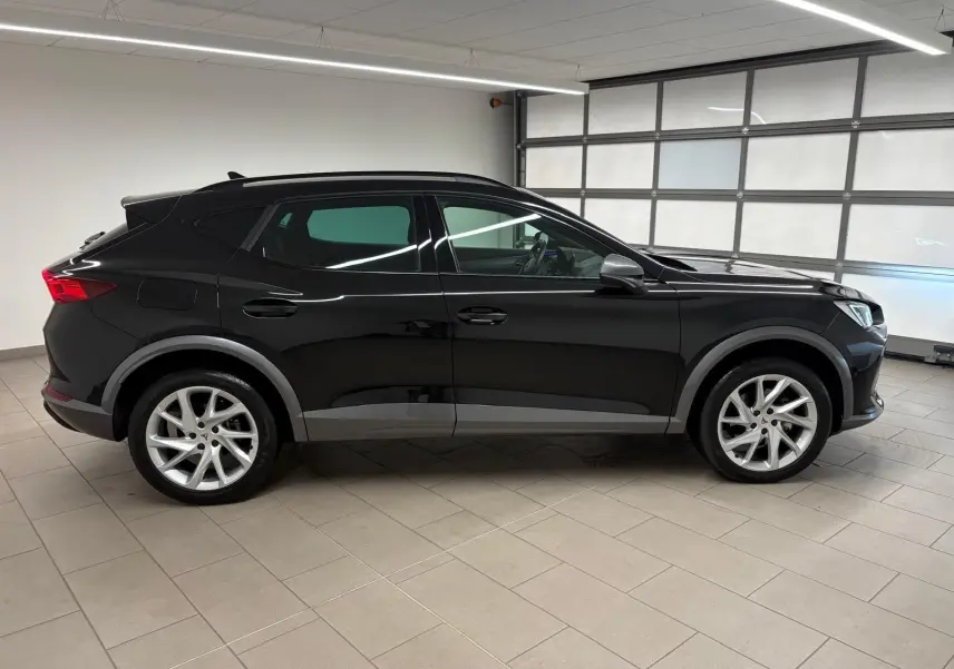 Vue de profil côté gauche du CUPRA Formentor 1.5 TSI 150 DSG7 en noir minuit, avec jantes argentées et détails noirs mats.