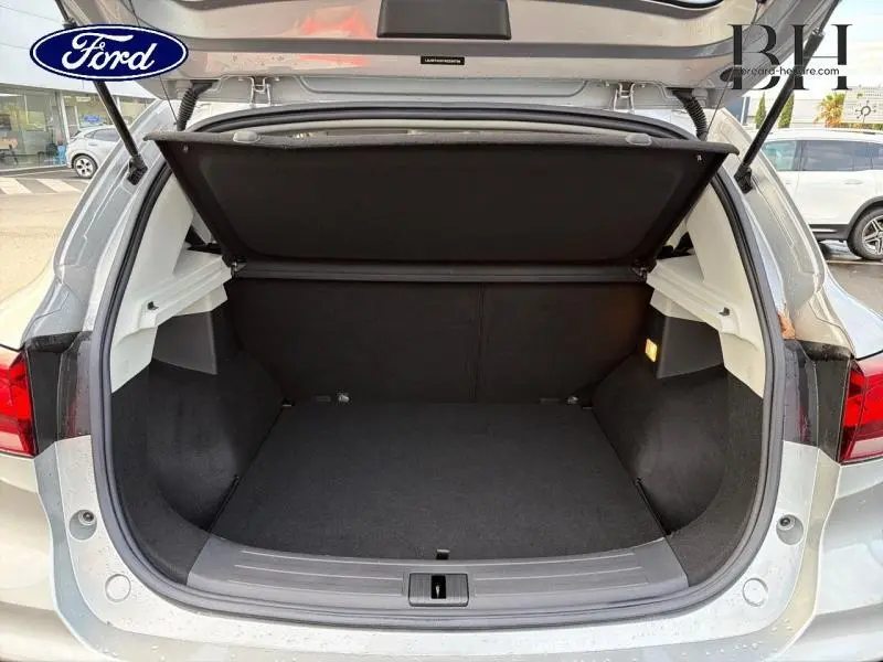 Coffre ouvert vu de l'arrière d'un MG ZS Cosmic Silver métallisé avec intérieur noir et éclairage latéral.