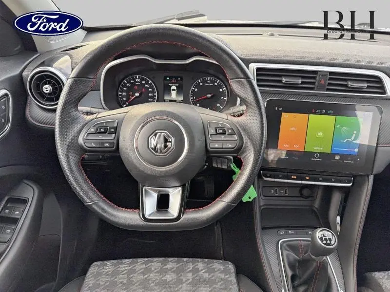 Vue intérieure centrée sur le volant cuir multifonction et l'écran tactile du MG ZS Cosmic Silver de 2022.