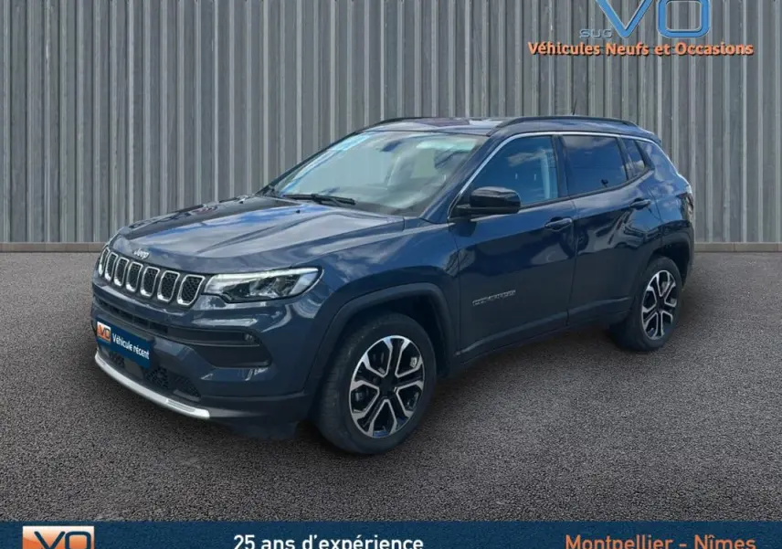 Vue 3/4 avant droite d'un Jeep Compass bleu 2023 avec barres de toit et jantes 18 pouces distinctives.