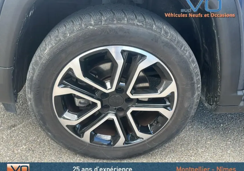 Gros plan sur la jante 18 pouces bicolore noir et argent du Jeep Compass bleu, vue côté droit.