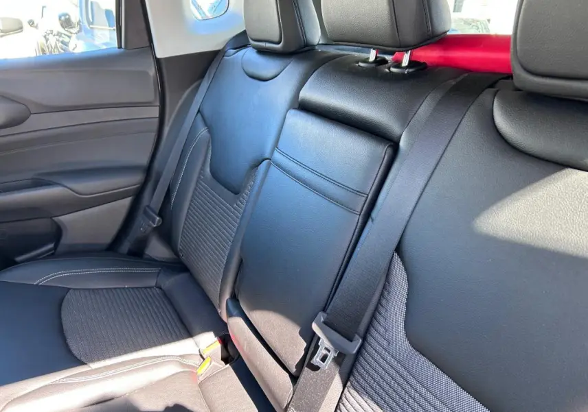 Vue intérieure côté gauche des sièges arrière noirs en cuir et tissu du Jeep Compass 2024 avec accoudoir central rabattable.