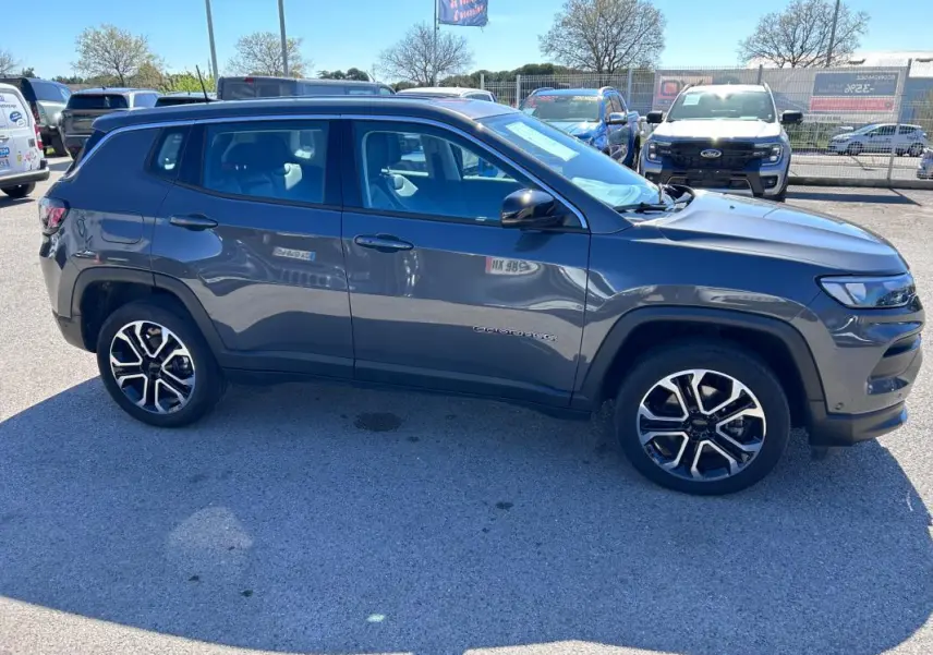 Vue de profil côté gauche d'un Jeep Compass gris 2024 avec jantes alliage 18 pouces et rétroviseurs noirs.