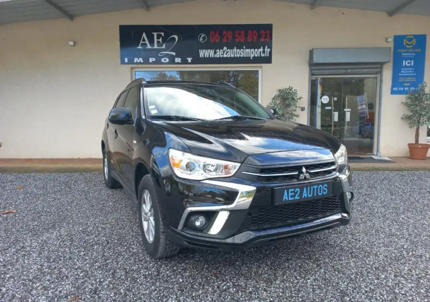 Mitsubishi ASX noir en 3/4 avant droit, avec calandre chromée et jantes 16 pouces visible sur parking gravillonné.