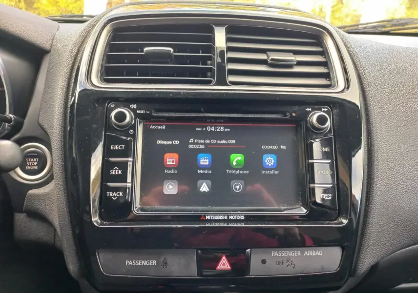 Vue rapprochée de la console centrale noire du Mitsubishi ASX 2020 avec écran tactile et commandes audio visibles.