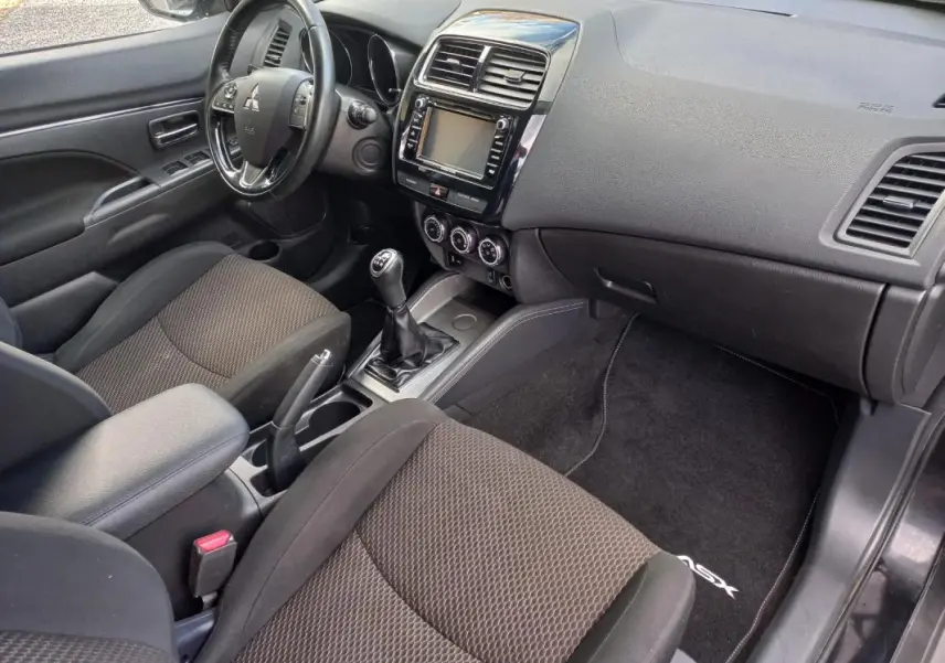Intérieur noir du Mitsubishi ASX 2020 vu côté conducteur, avec tableau de bord, volant et levier de vitesses manuel.