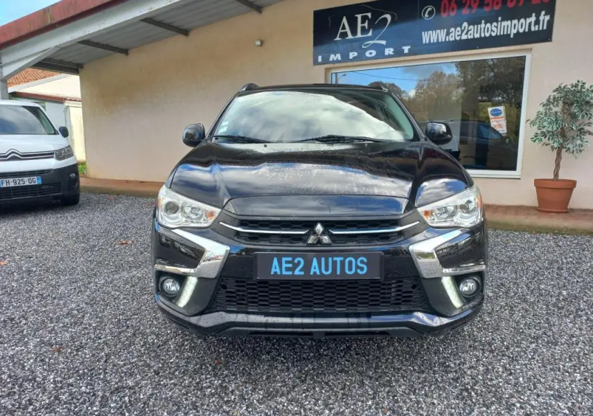 Vue avant d'un Mitsubishi ASX Invite 2WD noir 2020 avec calandre chromée et feux allumés en extérieur.