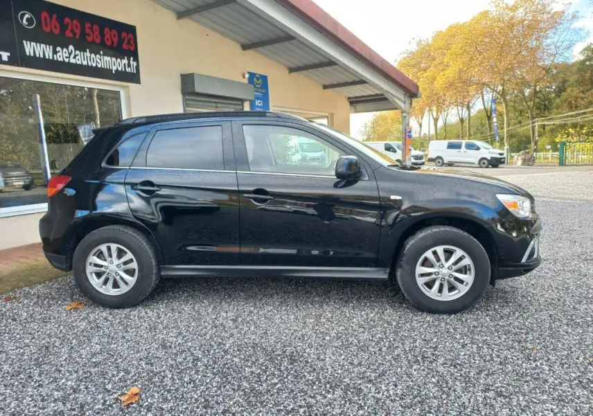 Vue de profil côté gauche d'un Mitsubishi ASX Invite 2WD noir 2020, stationné devant un bâtiment commercial.