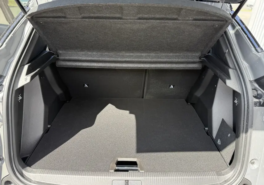 Coffre ouvert vu de l'arrière d'un Peugeot 2008 Hybrid gris selenium avec toit noir, montrant un espace de chargement vide.