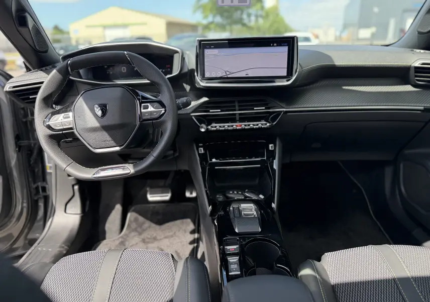 Vue intérieure avant du Peugeot 2008 Hybrid 145ch GT avec tableau de bord moderne et écran tactile central.
