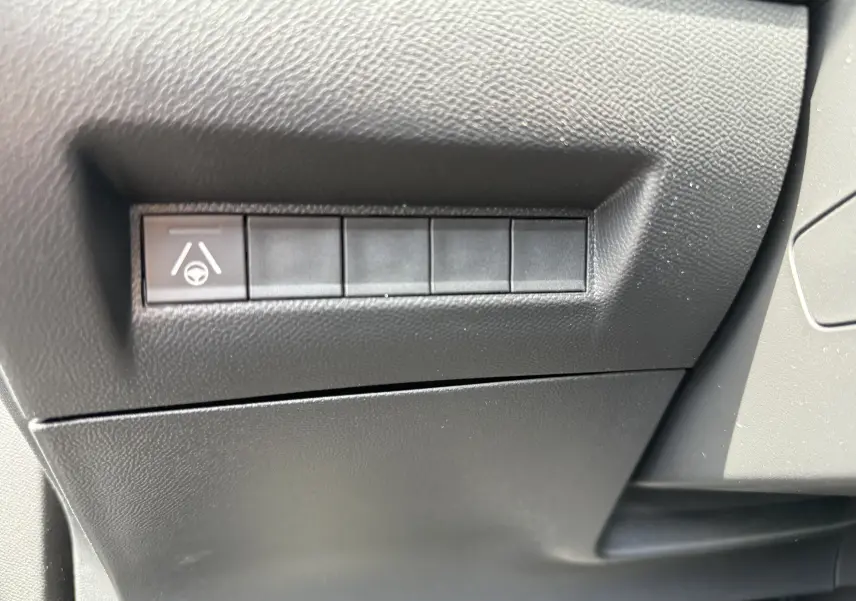 Gros plan sur le bouton d'assistance au maintien de voie dans l'habitacle noir du Peugeot 2008 Hybrid 145ch.