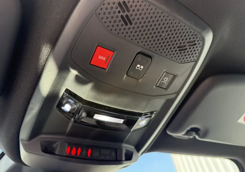 Vue en gros plan du plafonnier avec bouton SOS rouge et commandes d’éclairage dans un Peugeot 2008 gris selenium toit noir.