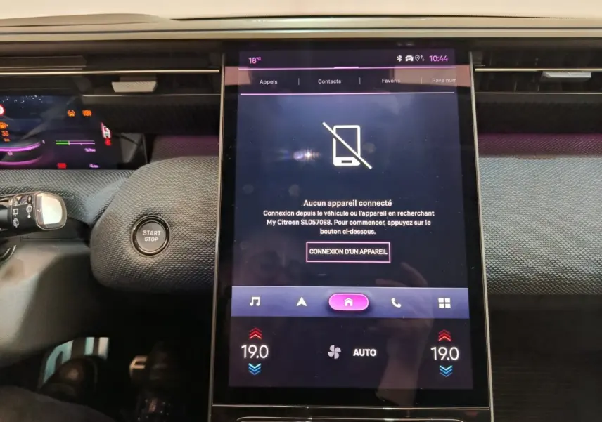 Vue rapprochée de l’écran tactile central allumé dans l’habitacle d’une Citroën C5 hybride gris foncé, avec bouton Start/Stop visible.