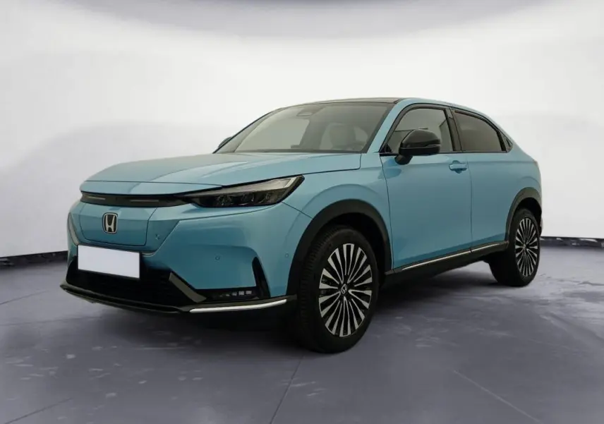 Vue 3/4 avant droite du Honda e:Ny1 204 ch Advance bleu électrique avec jantes distinctives et toit noir.
