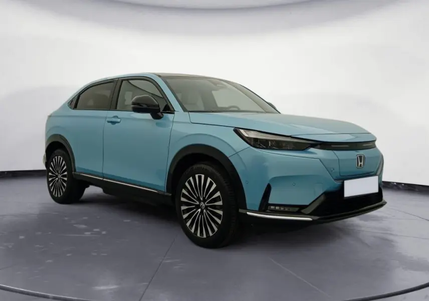 Honda e:Ny1 204 ch Advance bleu électrique, vue 3/4 avant droit, jantes stylisées et calandre épurée.