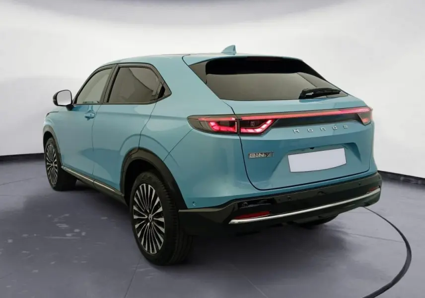 Vue 3/4 arrière droite d'un Honda e:Ny1 Advance 204 ch bleu électrique avec feux arrière LED et jantes stylisées.