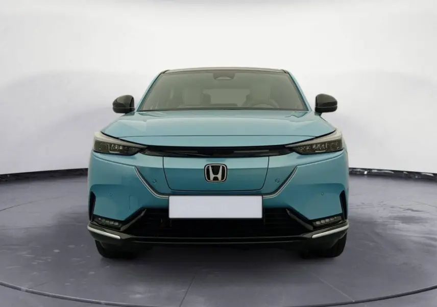 Vue avant d'une Honda e:Ny1 204 ch Advance 2025 en bleu électrique avec calandre lisse et phares fins.