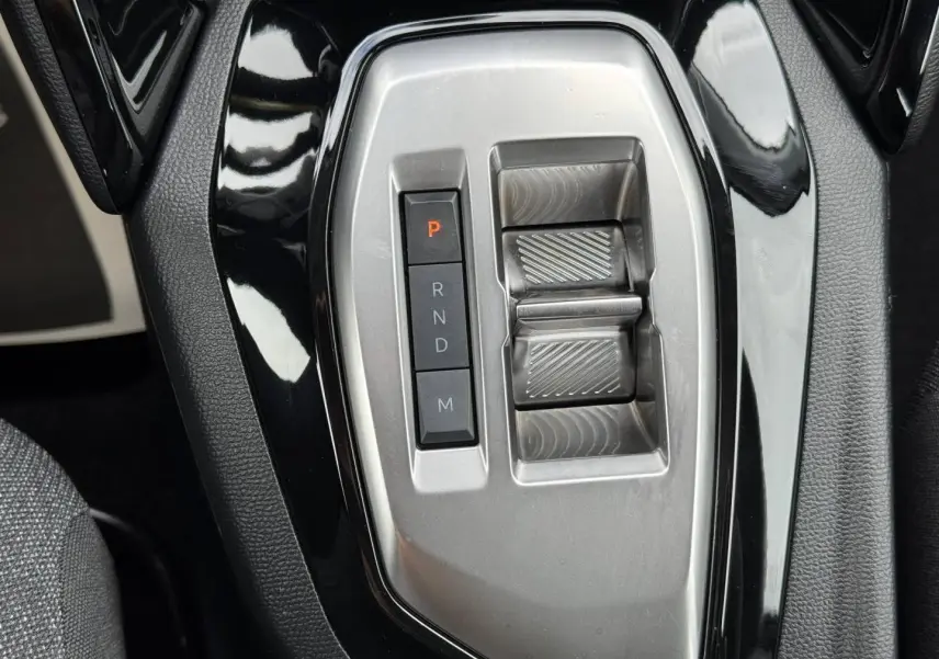 Gros plan sur la console centrale noire et argentée avec sélecteur de boîte auto de la Peugeot 208 1.2 Hybrid 110ch Style.
