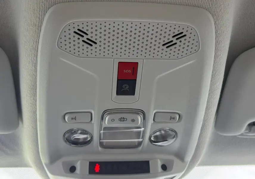 Vue en gros plan du plafonnier intérieur gris clair avec boutons SOS et éclairage de la Peugeot 208 noire.