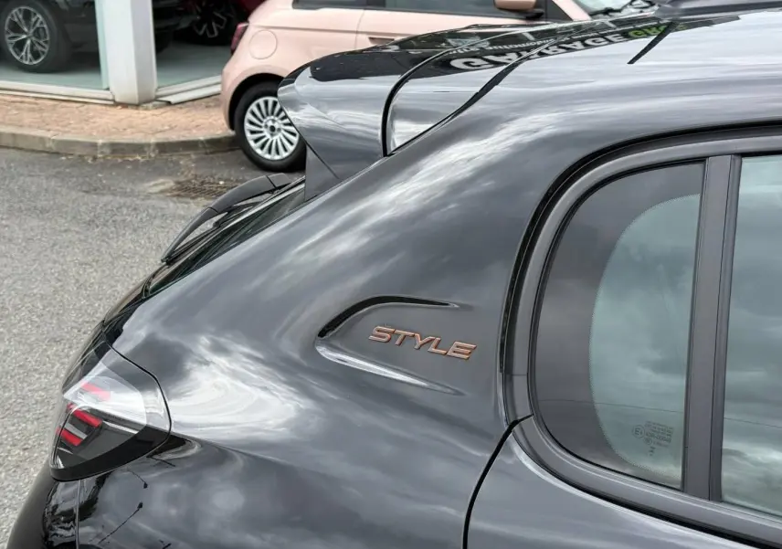 Vue arrière côté droit de la Peugeot 208 noire Perla Nera avec logo Style sur l'aile arrière.