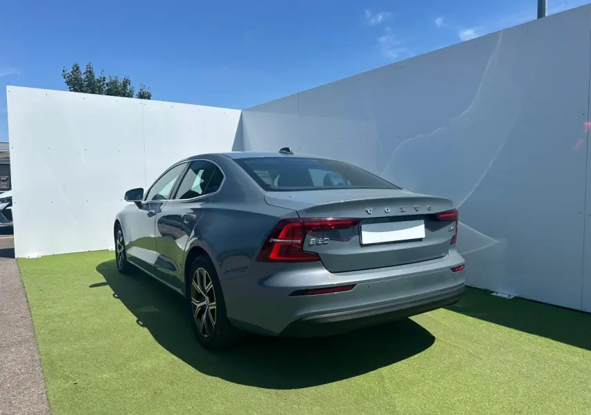 Vue 3/4 arrière droite d'une Volvo S60 2024 Thunder Grey Metal avec feux LED et jantes alliage 17 pouces.