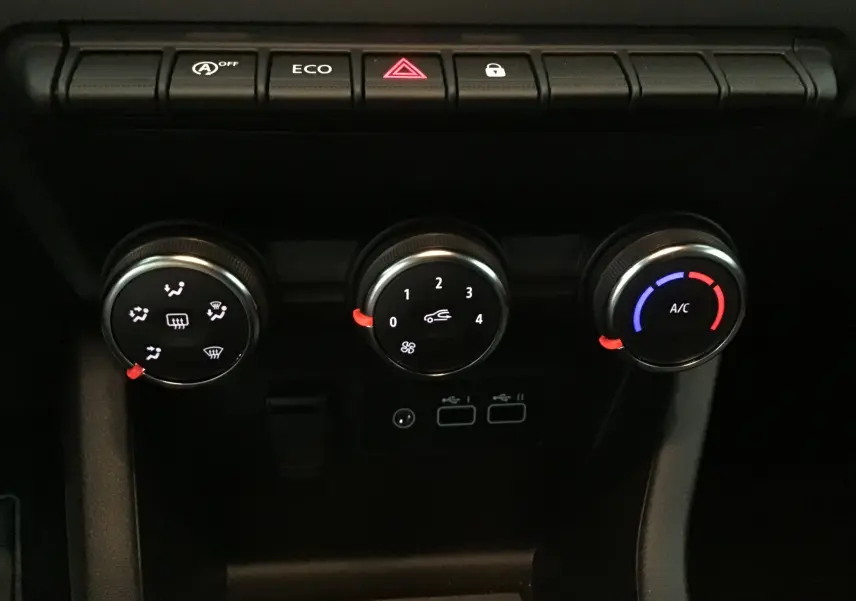 Commandes de climatisation avec réglages manuels et boutons de fonction sur la console centrale d'une Renault Clio V gris schiste.