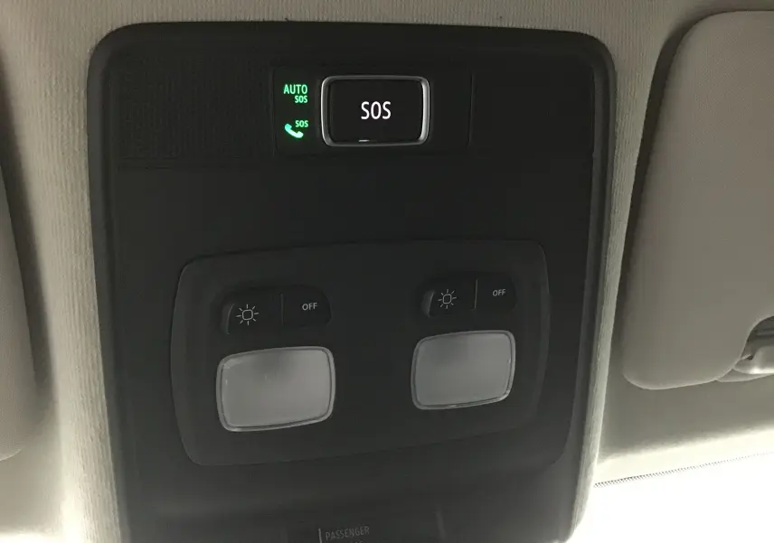 Bouton SOS et commandes d'éclairage intérieur au plafond d'une Renault Clio V gris schiste, vue en gros plan.