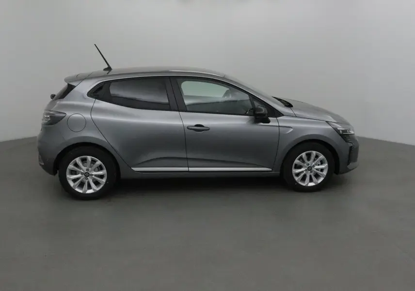 Profil côté gauche d'une Renault Clio V gris schiste 2025 avec protections latérales chromées en intérieur neutre.