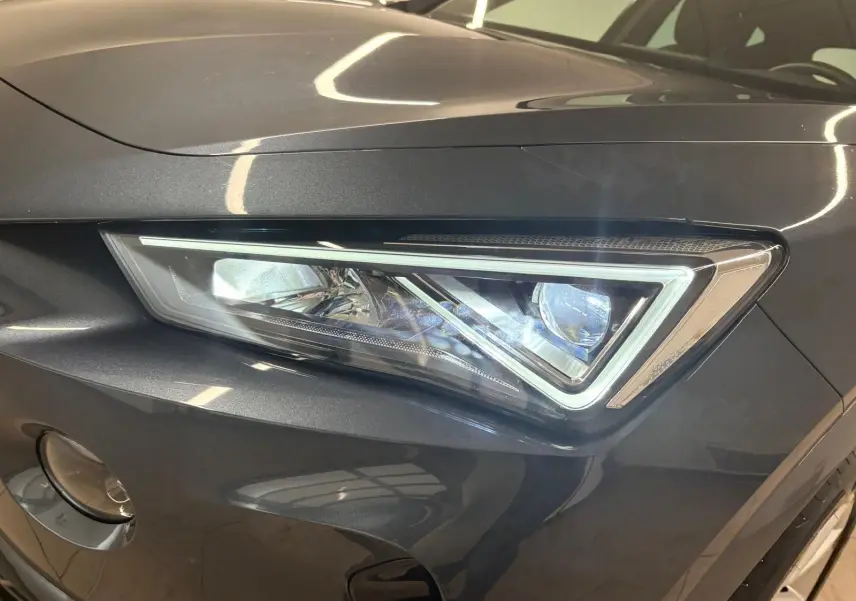 Gros plan sur le phare avant droit du CUPRA Formentor gris magnétique 2024 avec détails LED et carrosserie métallique.