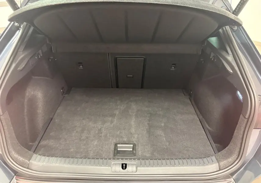 Coffre ouvert vu de l'arrière d'une CUPRA Formentor gris magnétique, montrant l'espace de chargement et la banquette rabattable.