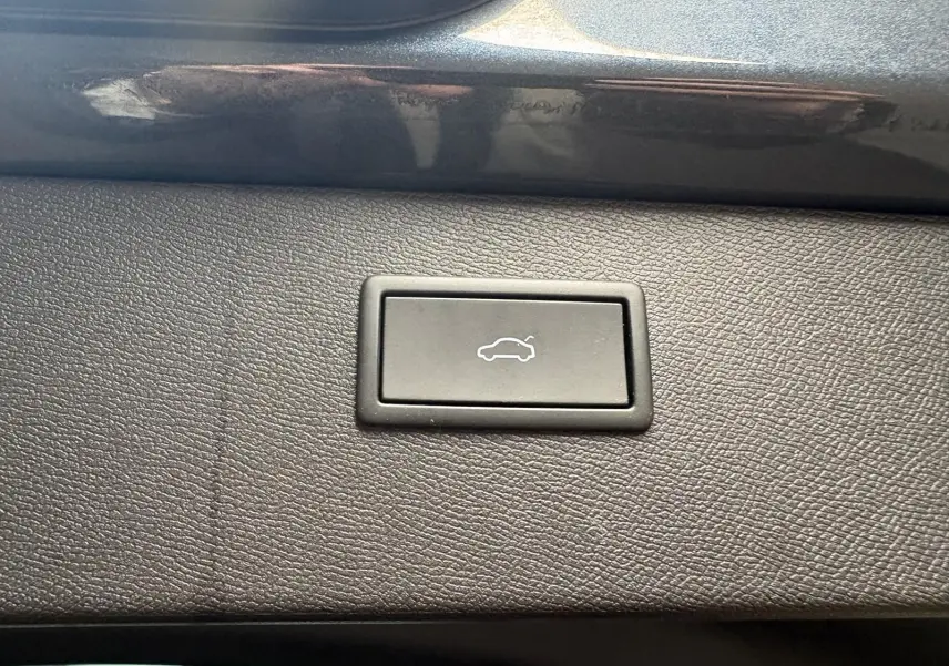 Bouton d'ouverture électrique du hayon sur la garniture intérieure d'un CUPRA Formentor gris magnétique, vue en gros plan.