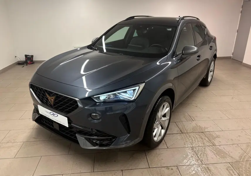 Vue 3/4 avant droit du CUPRA Formentor gris magnétique 2024, avec calandre noire et jantes argentées en intérieur.