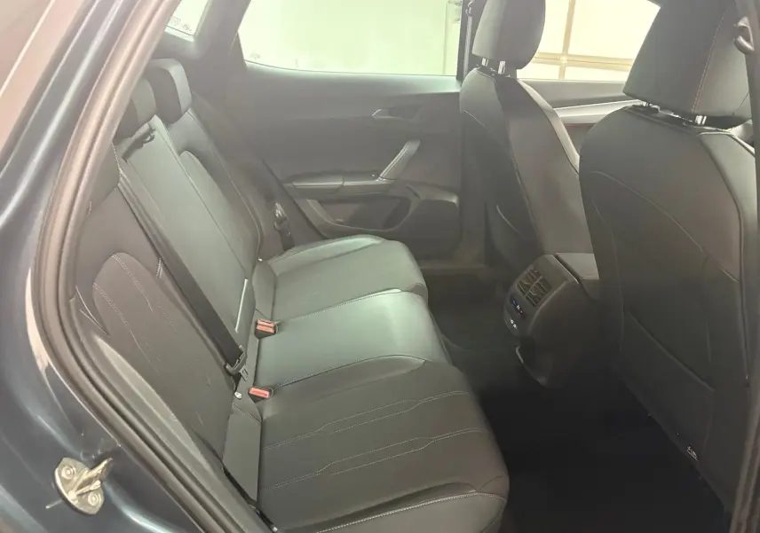 Vue intérieure côté arrière droit du CUPRA Formentor gris magnétique 2024, sièges cuir noirs avec surpiqûres contrastées.