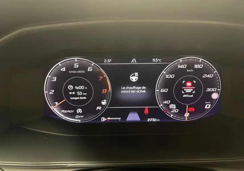 Vue rapprochée du tableau de bord numérique de la CUPRA Formentor gris magnétique, affichant le chauffage du volant activé.