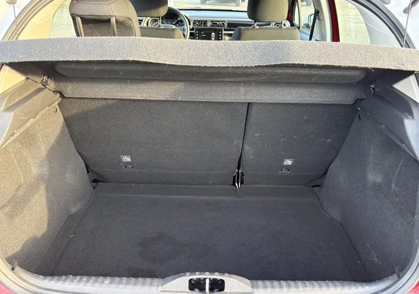 Vue du coffre ouvert d'une Citroën C3 rouge 2018, montrant l'espace de chargement et l'intérieur arrière du véhicule.