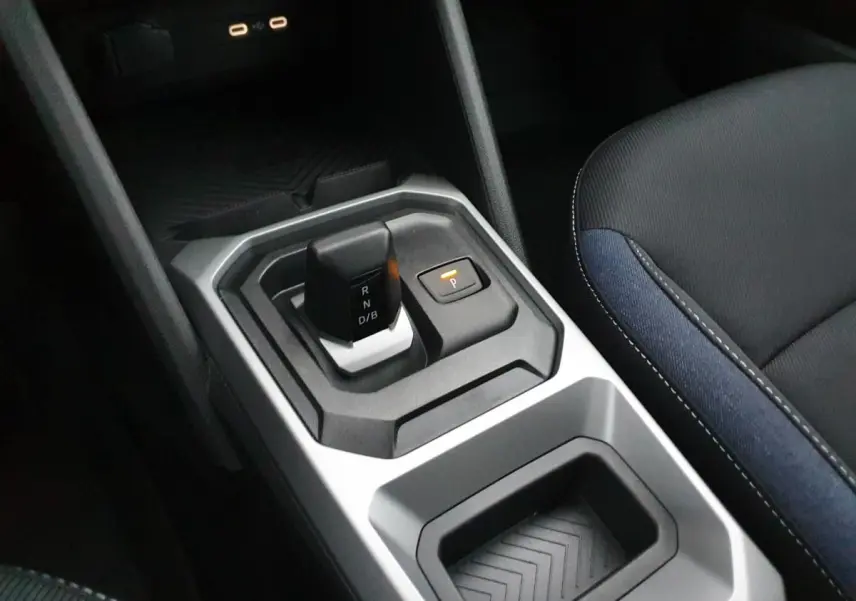 Vue rapprochée de la console centrale du Dacia Duster blanc glacier, avec levier de boîte auto et prises USB type C.