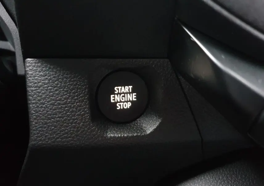 Gros plan sur le bouton Start Engine Stop noir dans l’habitacle du Dacia Duster blanc glacier 2025.